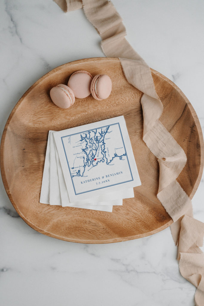 Newport Rhode Island map napkins sitting on a wooden bowl with a pink ribbon.